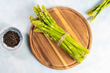 Green Asparagus on a wooden plate