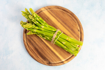 Green Asparagus on a wooden plate