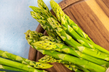 Green Asparagus on a wooden plate