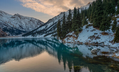 Mountain lake in the vicinity of the Kazakh city of Almaty and snow-covered mountains in the early morning