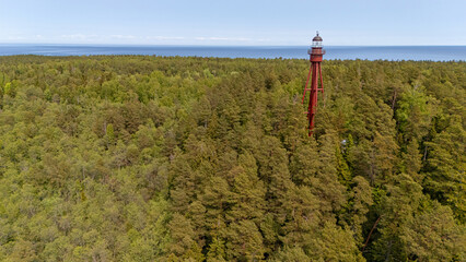 Ruhnu lighthouse rises above the lush forest on Ruhnu island in Estonia