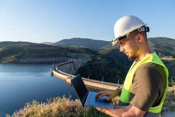 Engineer analyzing data on a tablet near a renewable energy plant