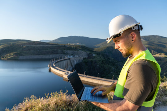 Engineer analyzing data on a tablet near a renewable energy plant