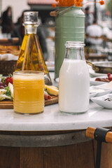 Milk Bottle and Glass of Orange Juice on Breakfast Table-Natural Dairy and Fruit Juice for Morning Meal-