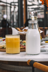 Milk Bottle and Glass of Orange Juice on Breakfast Table-Natural Dairy and Fruit Juice for Morning...