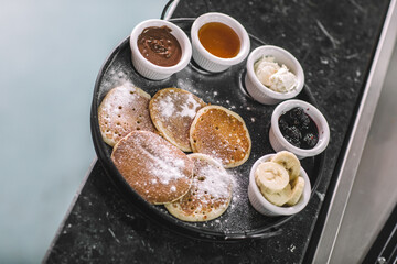 Pancake Breakfast Tray with Chocolate, Banana, Honey, Jam, and Cream-Pancake Brunch with Mixed Sweet Sauces and Fruit Garnish