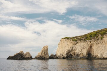 Barefoot tourists wander sunburnt stone paths lined with olive trees, enveloped in the serenity of...