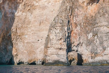 A barefoot traveler strolls along a sun-drenched stone path past ancient olive trees, soaking in the nostalgic Mediterranean ambiance and clutching a vintage postcard of a ghost ship