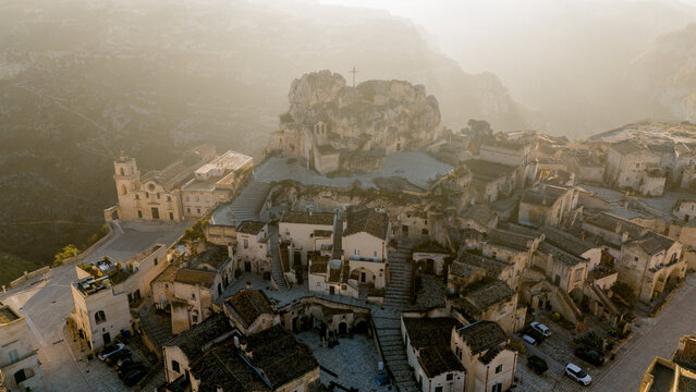 Drone view of Materas iconic rock-hewn church, Chiesa di Santa Maria di Idris, glowing in soft morning light. A hauntingly beautiful symbol of the citys ancient heritage.