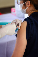 Concept of vaccination against epidemic, woman wearing medical face mask is getting vaccinated against epidemic at hospital medical center
