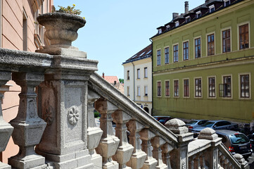 old style stone stairs and balustrade in urban downtown area. colorful classic stucco exterior elevations with windows. carved stone guard rail. travel and tourism concept. blue sky. summer scene.