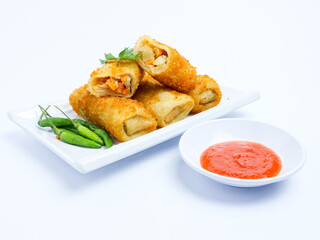 Indonesian risoles filled with vegetables, served with fresh green chilies on a white plate. Crispy breadcrumb coating on white background