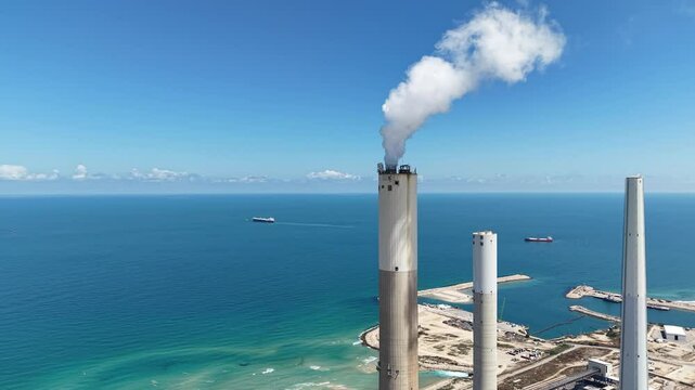 industrial smokestacks emitting plumes of smoke or steam into the atmosphere does climate change and energy	
