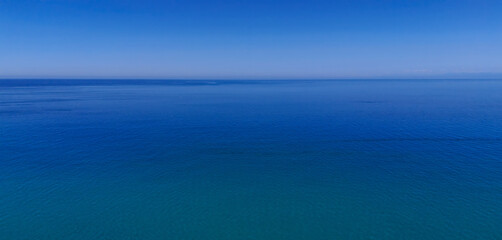 Stunning aerial view of the calm Tyrrhenian Sea near Tropea, Calabria, Italy, with a clear blue sky