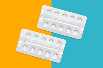 Round metal packs of tablets on a yellow-blue background