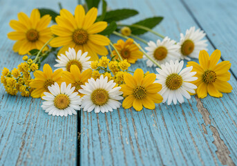 Obraz premium Yellow daisies and white daisies present a fresh spring blossom display arranged on a light blue wooden board
