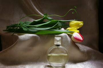 Colorful floral still life with multi-colored tulips and perfume
