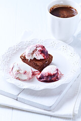 Strawberry ice cream with chocolate and cherry syrup on chocolate brownie. Selective focus.