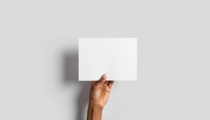 Obraz premium Hand holding blank poster against a grey background 