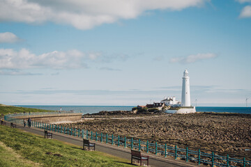 Whitley Bay UK: 13th April 2025: St Mary's Lighthouse showcasing iconic structure against the tranquil waters of Whitley Bay on a clear sunny day