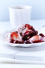 Strawberry ice cream with chocolate and cherry syrup on chocolate brownie. Selective focus.