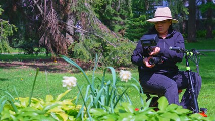 A female videographer person with physical disability, using and riding a three wheel wheelchair or e scooter for video recording and content creating. Freedom and independence concept.