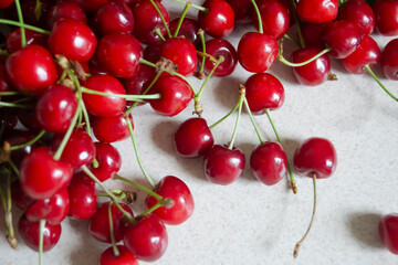Fresh red cherries arranged on a light surface showcasing their vibrant color and shiny texture in a casual setting