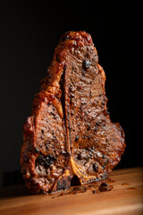 High Quality Juicy Artistic T-Bone Steak Standing straight up on wood cutting board