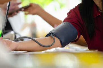Annual checkup concept. Doctor is measuring patient's blood pressure. The patient has a blood pressure cuff on his arm.
