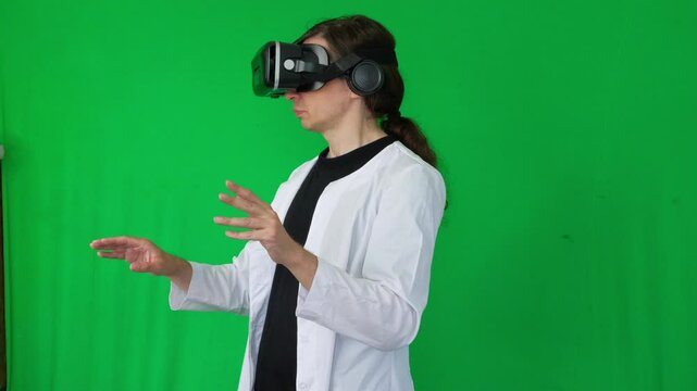  A mid-shot captures an immersive and futuristic mood as a person in a white lab coat and VR headset makes hand gestures, suggesting virtual reality interaction or gaming, green screen background