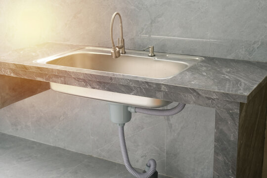 modern kitchen sink installed on grey marble concept

