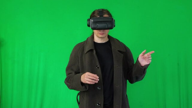 A mid-shot captures an immersive and interactive mood as a person in a dark overcoat and VR headset gestures with both hands, suggesting engagement with a virtual environment or data
