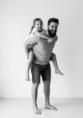 Father Giving Daughter a Piggyback Ride – Joyful Black and White Portrait