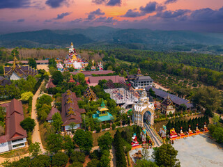 Fototapeta premium Aerial view of wat sang kaew phothiyan temple and scenic landscape at sunset in chiang mai, Thailand