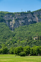 Vertical view of a waterfall cascading down a rocky cliff near Trento, Italy