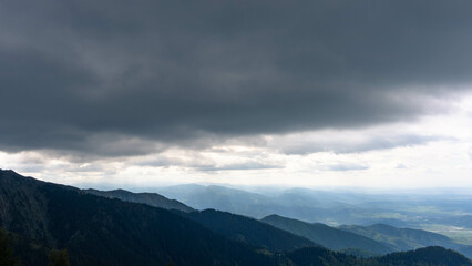 Fototapeta premium top view from mountain ladder landscape with clouds in summer carpathians romania with lights below clouds and green forests