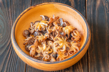 Golden Fried Garlic Octopuses Served In Rustic Wooden Bowl With Crisp Edges
