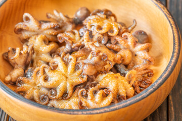 Golden Fried Garlic Octopuses Served In Rustic Wooden Bowl With Crisp Edges