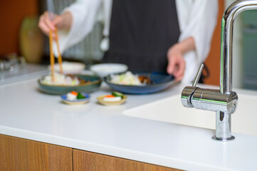 料理の盛り付けに集中する女性の柔らかな雰囲気