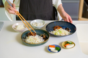 料理を箸で取り分ける手元が伝える丁寧な暮らし