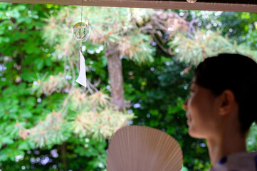 風鈴を眺める男性の姿が映し出す涼しげな縁側の午後