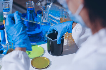Scientist pipetting medical samples into microplate in laboratory