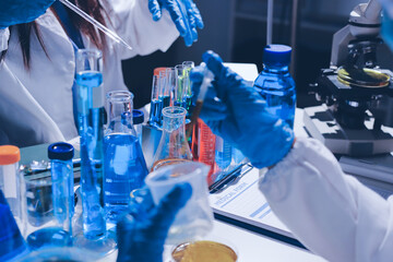 Scientist pipetting medical samples into microplate in laboratory