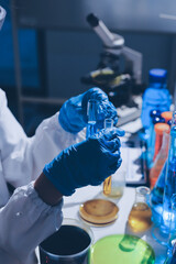 Scientist pipetting medical samples into microplate in laboratory