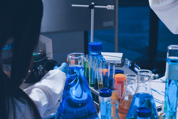Scientist pipetting medical samples into microplate in laboratory