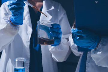 Scientist pipetting medical samples into microplate in laboratory