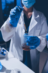 Scientist pipetting medical samples into microplate in laboratory