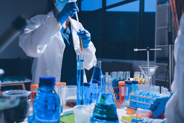 Scientist pipetting medical samples into microplate in laboratory