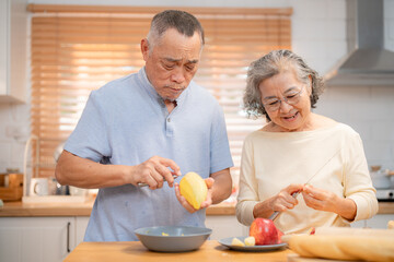 Elderly couple cooking in a cozy kitchen while preparing fresh fruits and vegetables together