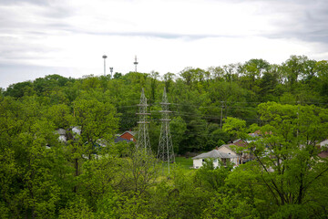 Power Lines Crossing Suburban Neighborhood in Green Forest Area